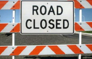 Construction barricade with road closed sign on it