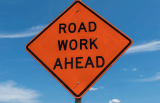 Road work ahead sign with sky background